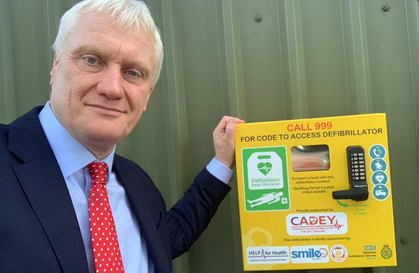 Graham standing next to an Automated External Defibrillator